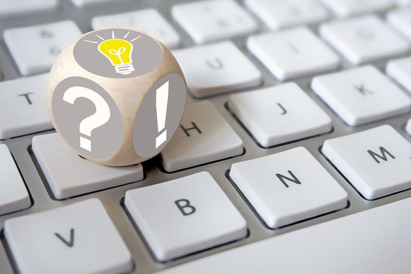Foto: Würfel auf Tastatur mit Rufzeichen und Fragezeichen