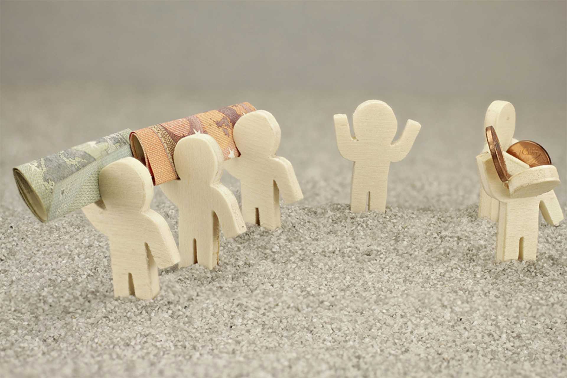 Kleine Figuren mit Geldscheinen und Münzen