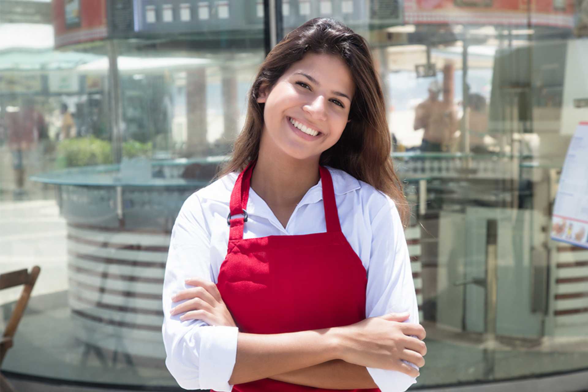 Junge Kellnerin vor dem Restaurant