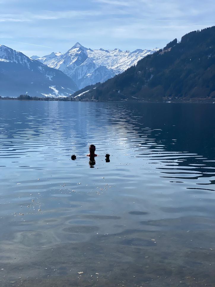 Mann Eisbadet im See, im Hintergrund sieht man das Kitzsteinhorn