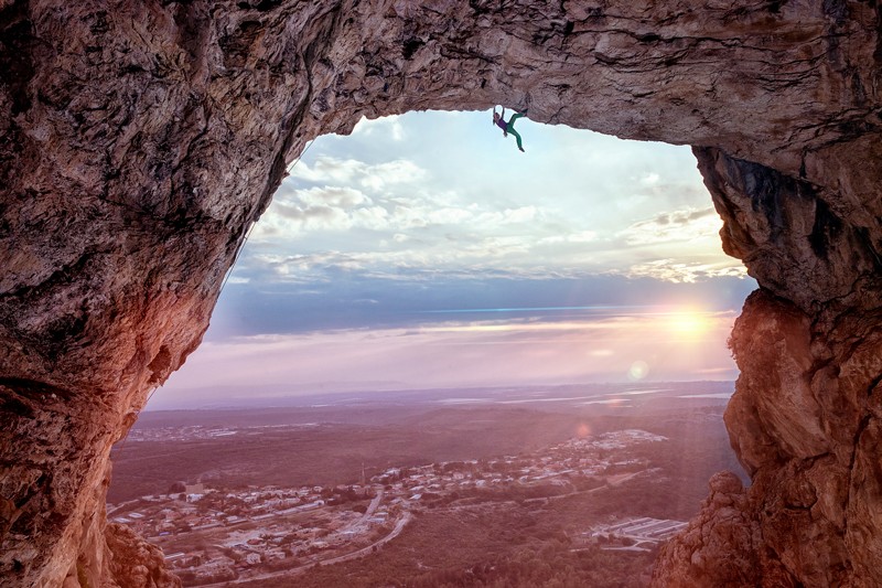 Kletterin hängt von Steinwand in Israel